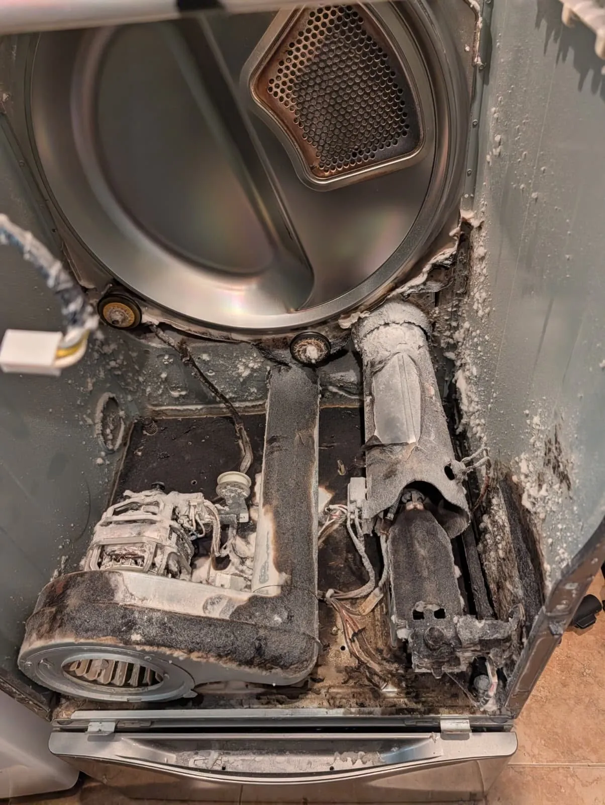 Severely lint-clogged dryer interior exposed for cleaning and repair.
