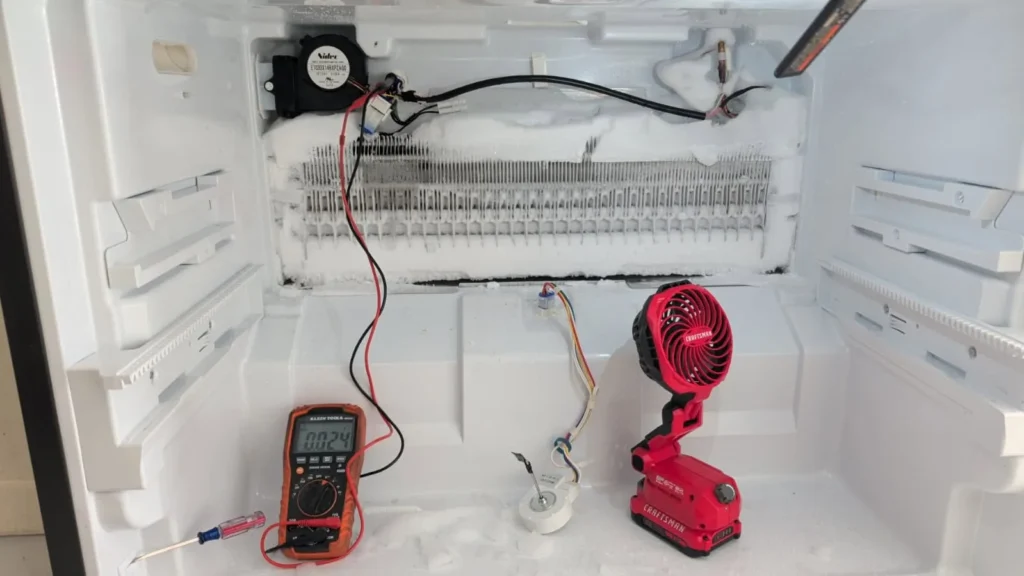 Refrigerator evaporator system tested with a multimeter and power tool.