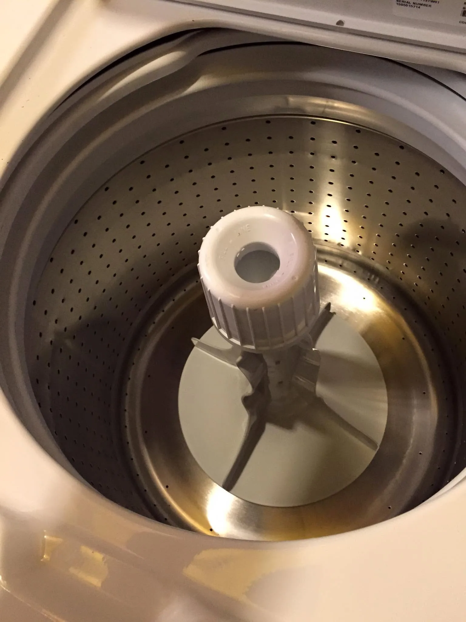 Top-load washer basket and agitator inspected from above.