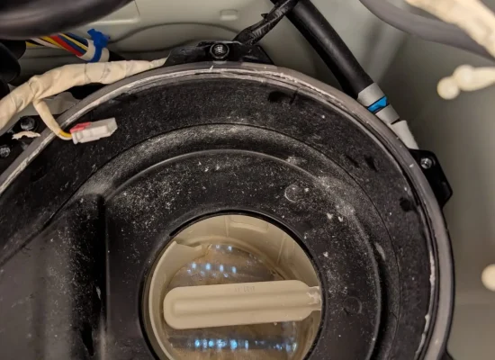 Dishwasher circulation pump housing exposed for inspection.