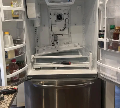 French-door refrigerator interior disassembled for cooling-system repair.