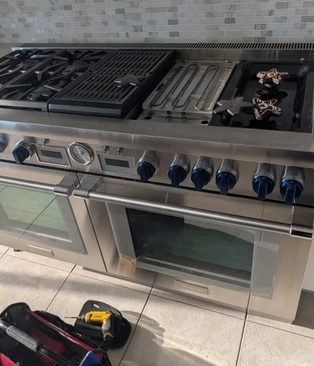 Stainless professional gas range prepared for repair in a Staten Island kitchen.