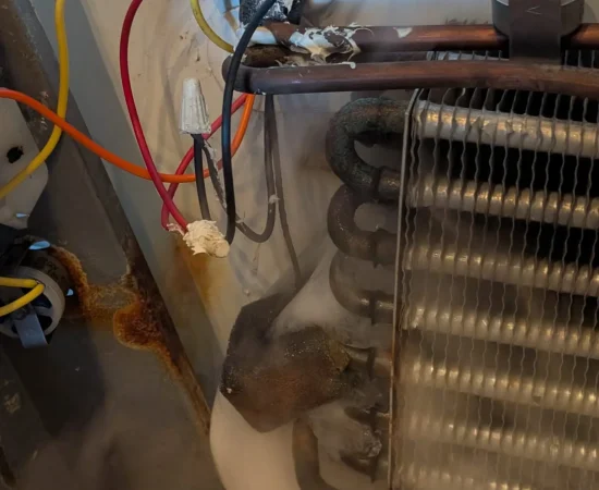 Refrigerator sealed-system lines connected to service gauges for testing.