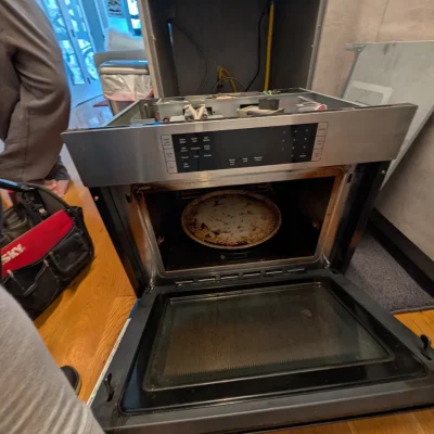 Wall oven control panel pulled forward for electrical repair.