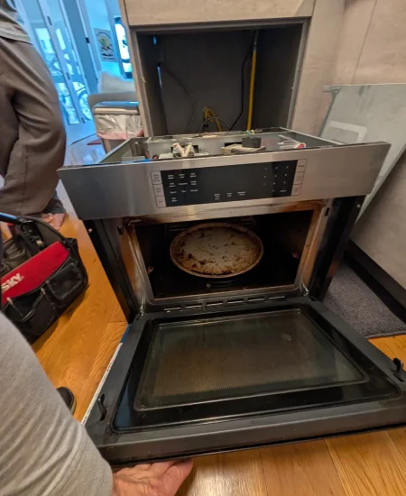 Wall oven control panel pulled forward for electrical repair.
