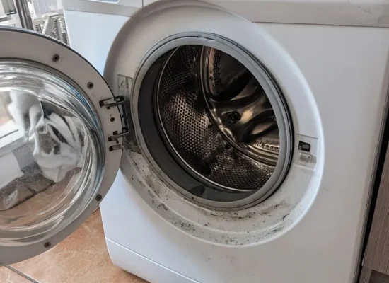 Front-load washer open with the drain pump removed for service.