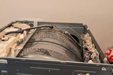 Washing machine cabinet opened to expose the drum and outer tub.